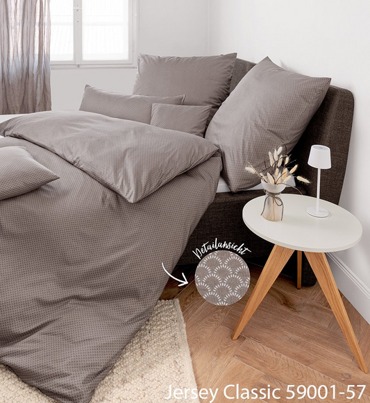 Janine Jersey Classic Interlock-Jersey Bettwäsche in einem Grauton mit feinem Muster auf einem Bett